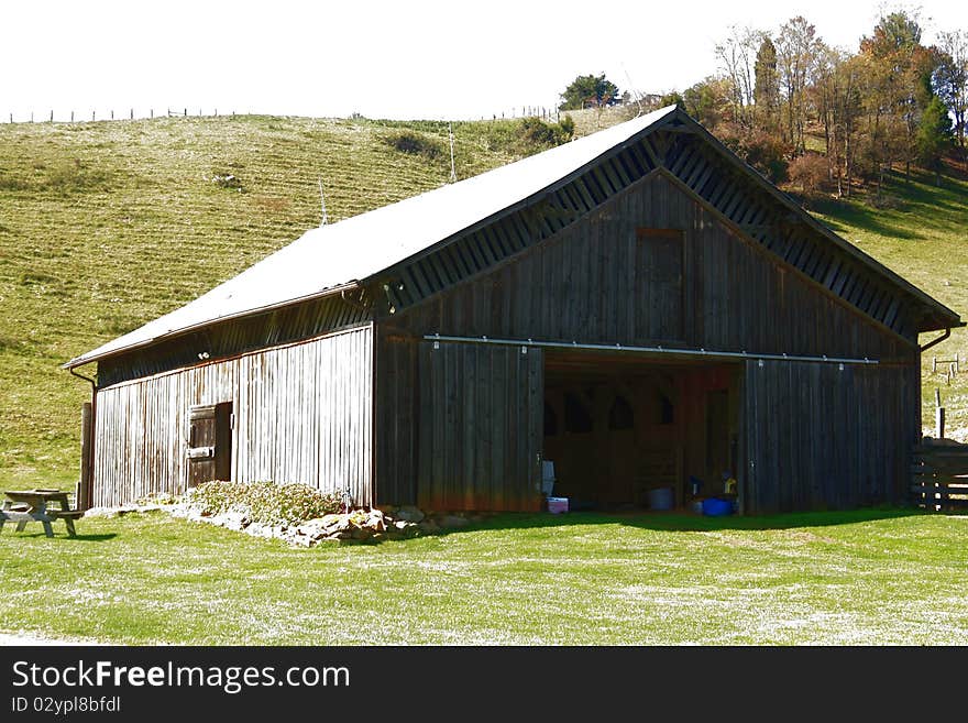 Old plank barn with hills in background