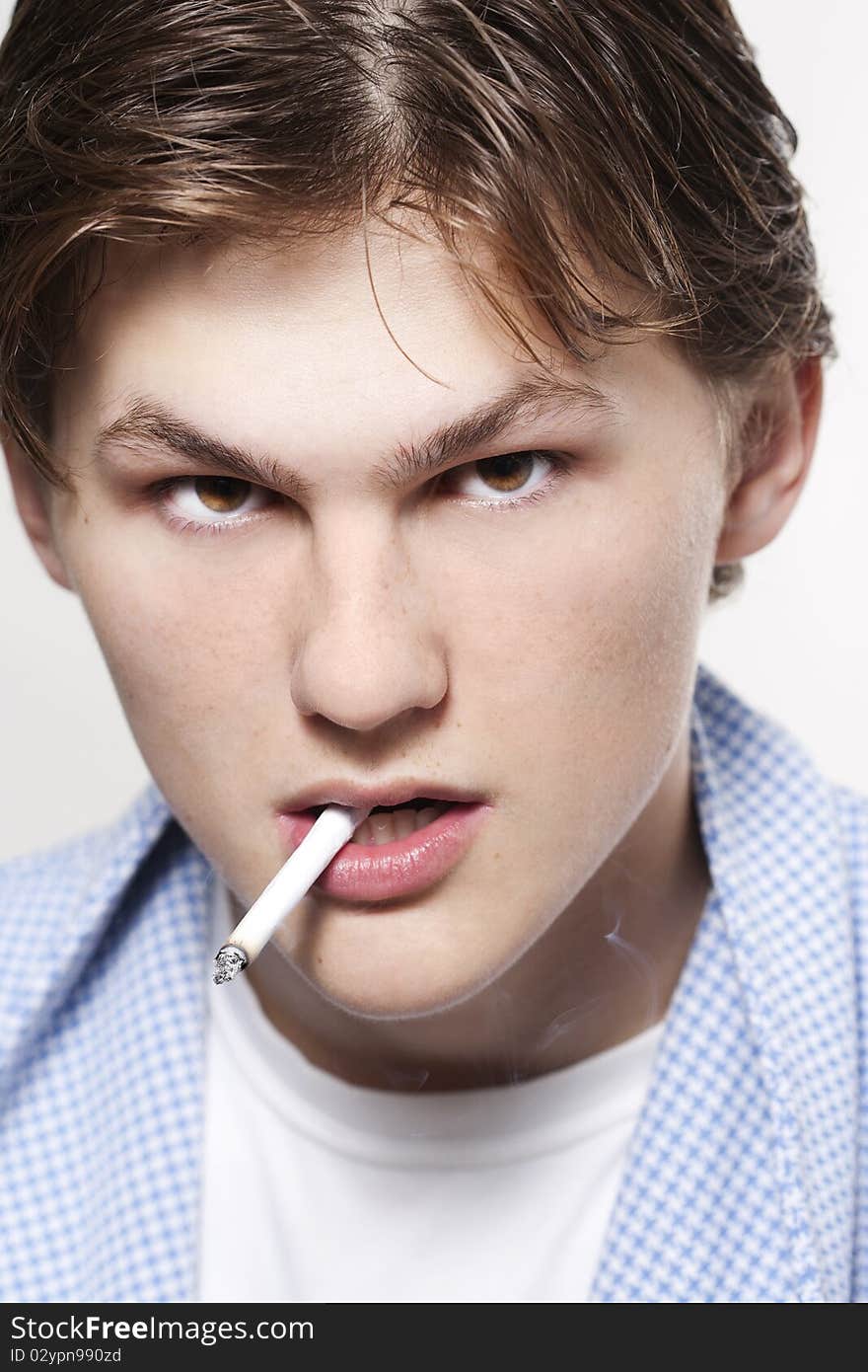 A portrait of a young man smoking a cigarette