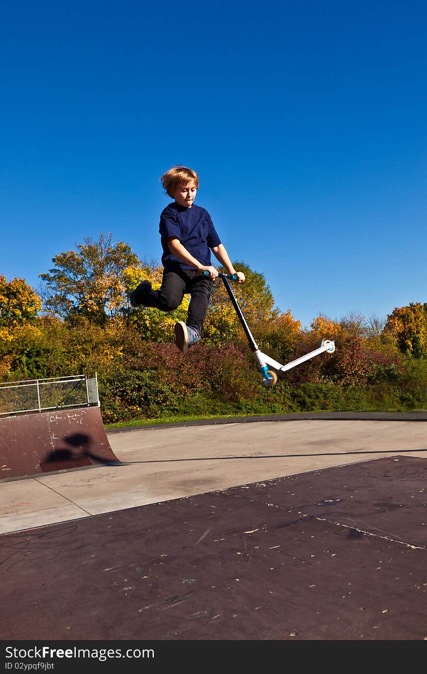 Young boy going airborne with scooter