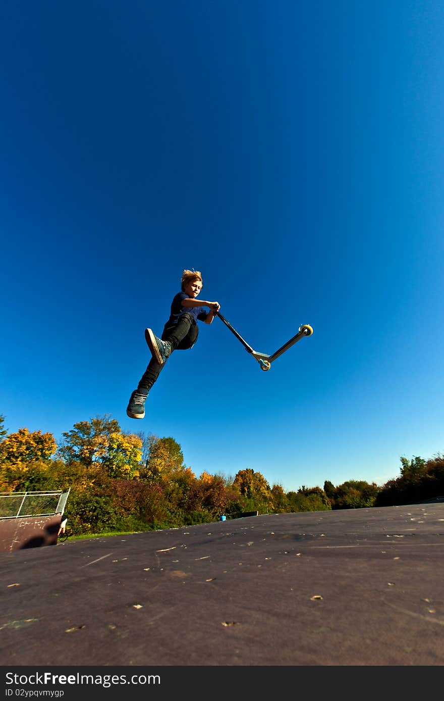 Young boy going airborne with his scooter