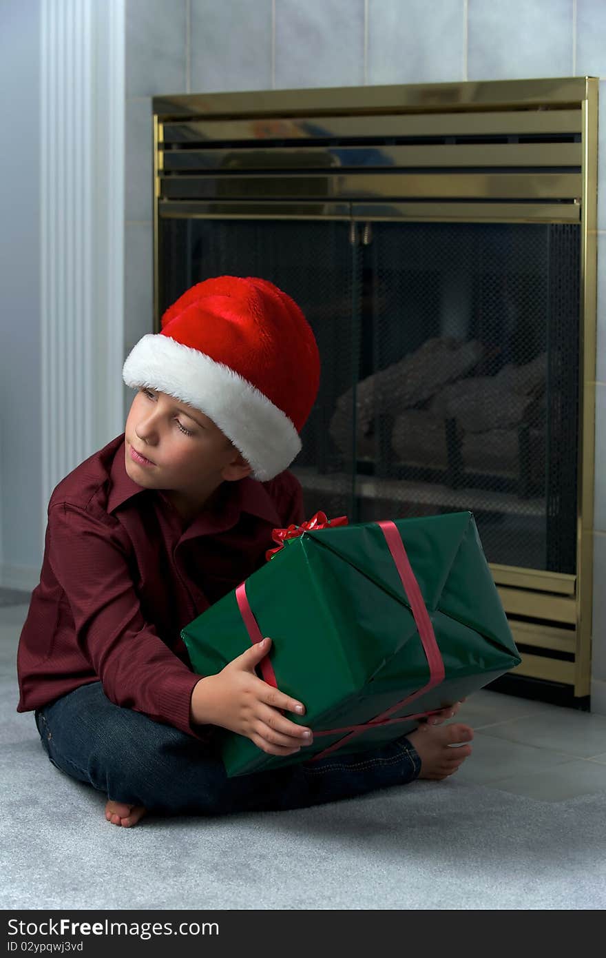 Boy in santa hat shaking gift