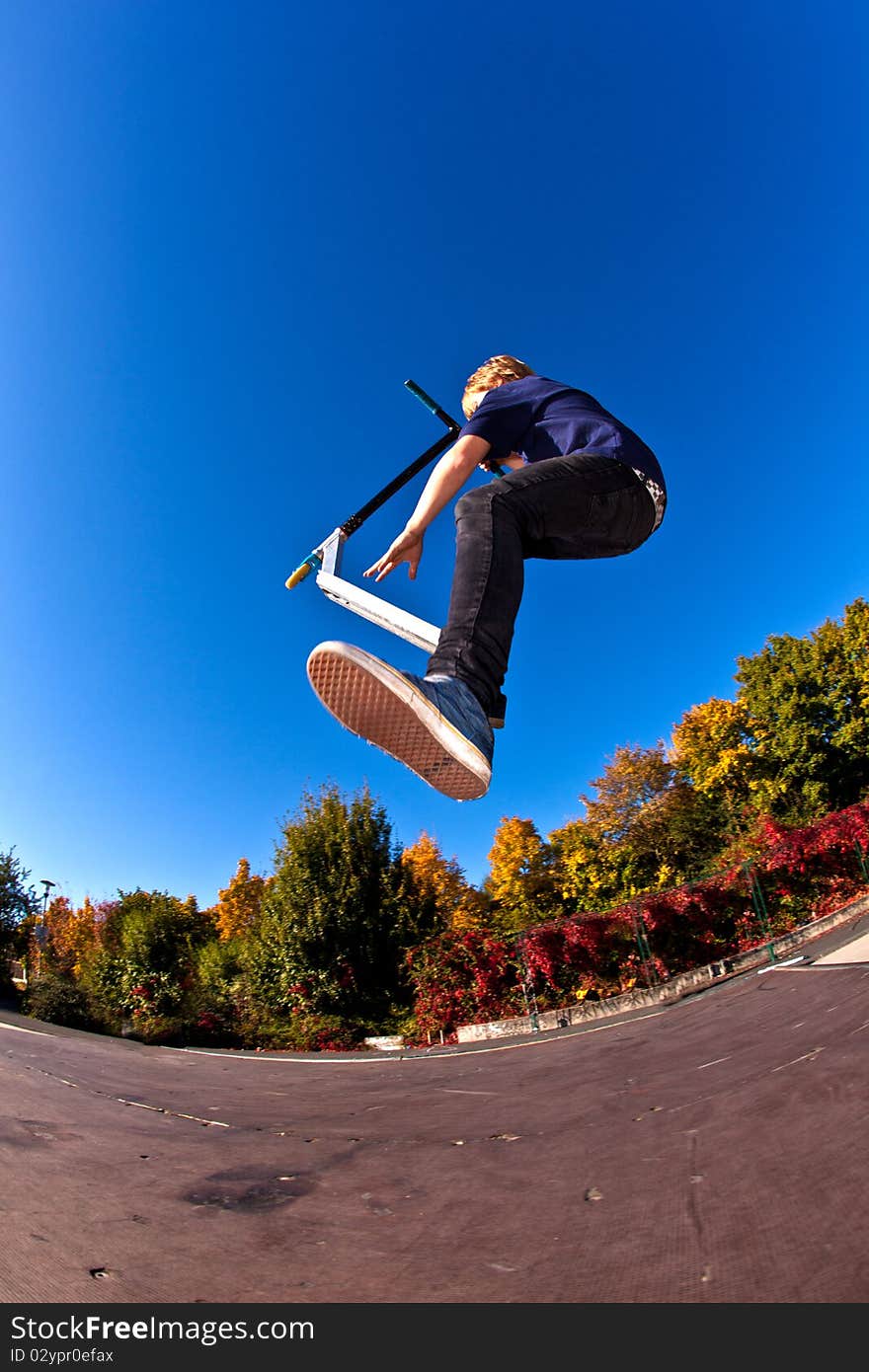 Young boy going airborne with his scooter