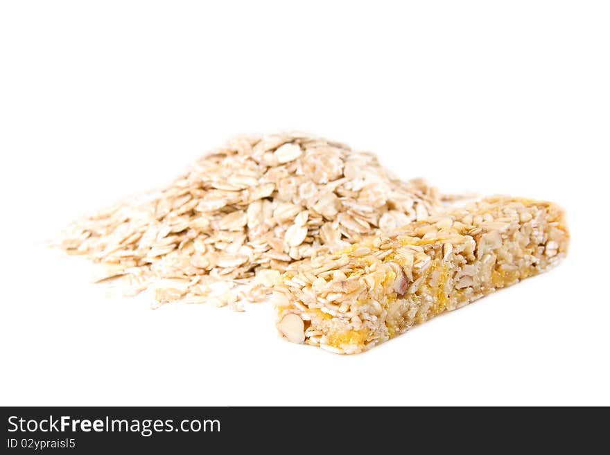 Muesli snack stick and oat flakes isolated on white