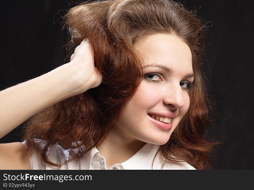 Girl dishevelled hair by hand isolated black