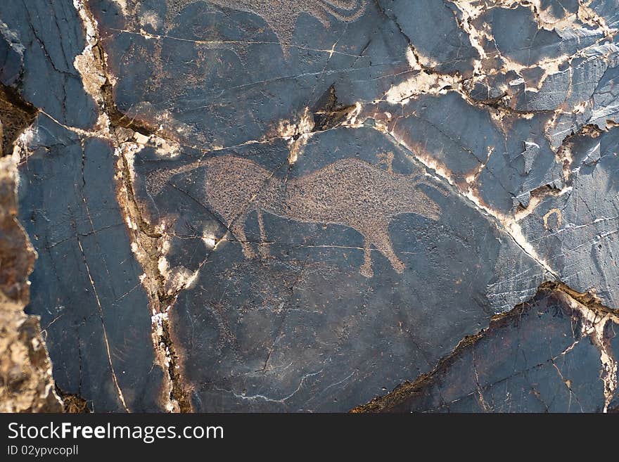 Petroglyph carved into rock surface by prehistoric asian nomads. Sarmishsay, Uzbekistan