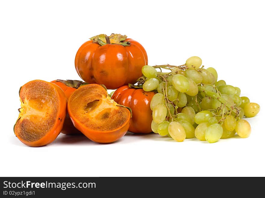 Ripe persimmons and grapes isolated on a white background