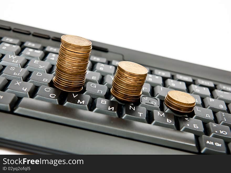 Stacks of coins on a black computer keyboard