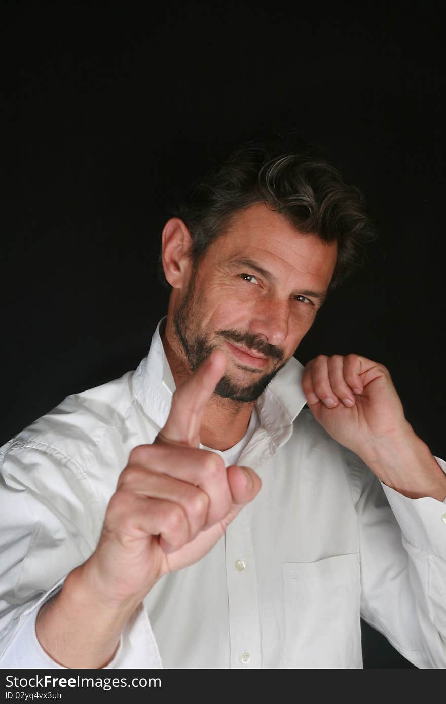 Portrait of man with beard showing with his finger on black background. Portrait of man with beard showing with his finger on black background