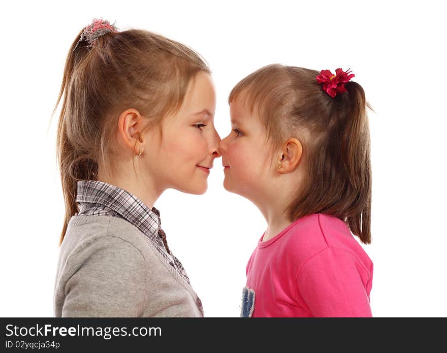 Two cute young sisters posing together in a studio