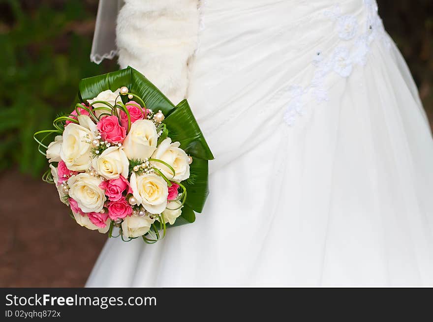 Bride and groom near the fountain with wedding bouquet