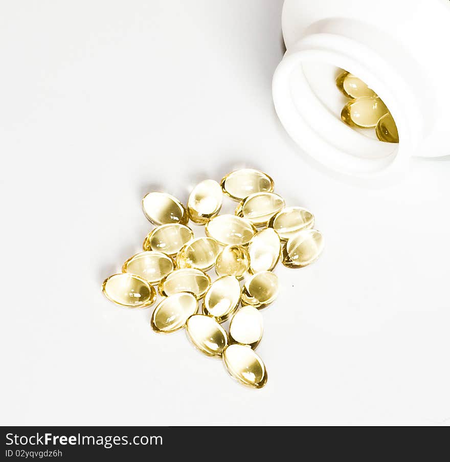 Yellow pills and a package of pills isolated on white