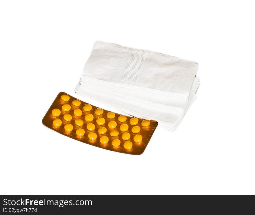 Orange pills in a package and white tissues isolated on white