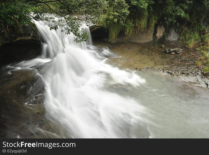 It is a waterfall in the cloudy day