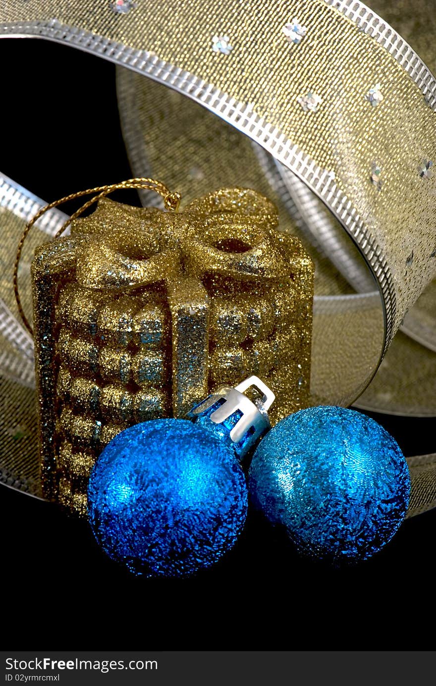 Golden and blue christmas balls and golden and silver wide ribbon on black background. Golden and blue christmas balls and golden and silver wide ribbon on black background