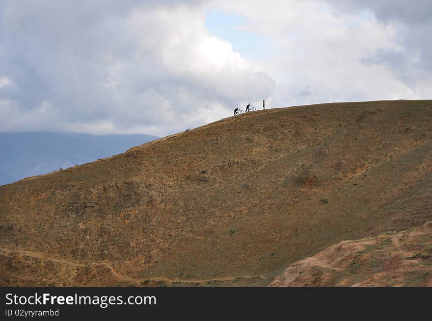 Bikers on the hill on a cloudy day