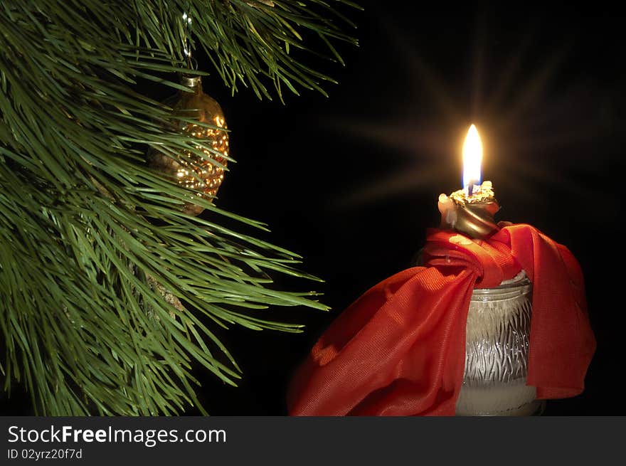 Burn red candle with green pine branch on dark background. Burn red candle with green pine branch on dark background