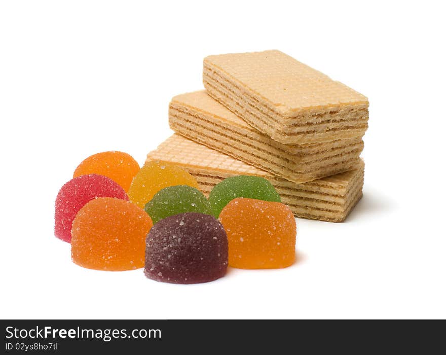 Multi-colored fruit candy and wafers on a white background. Multi-colored fruit candy and wafers on a white background.