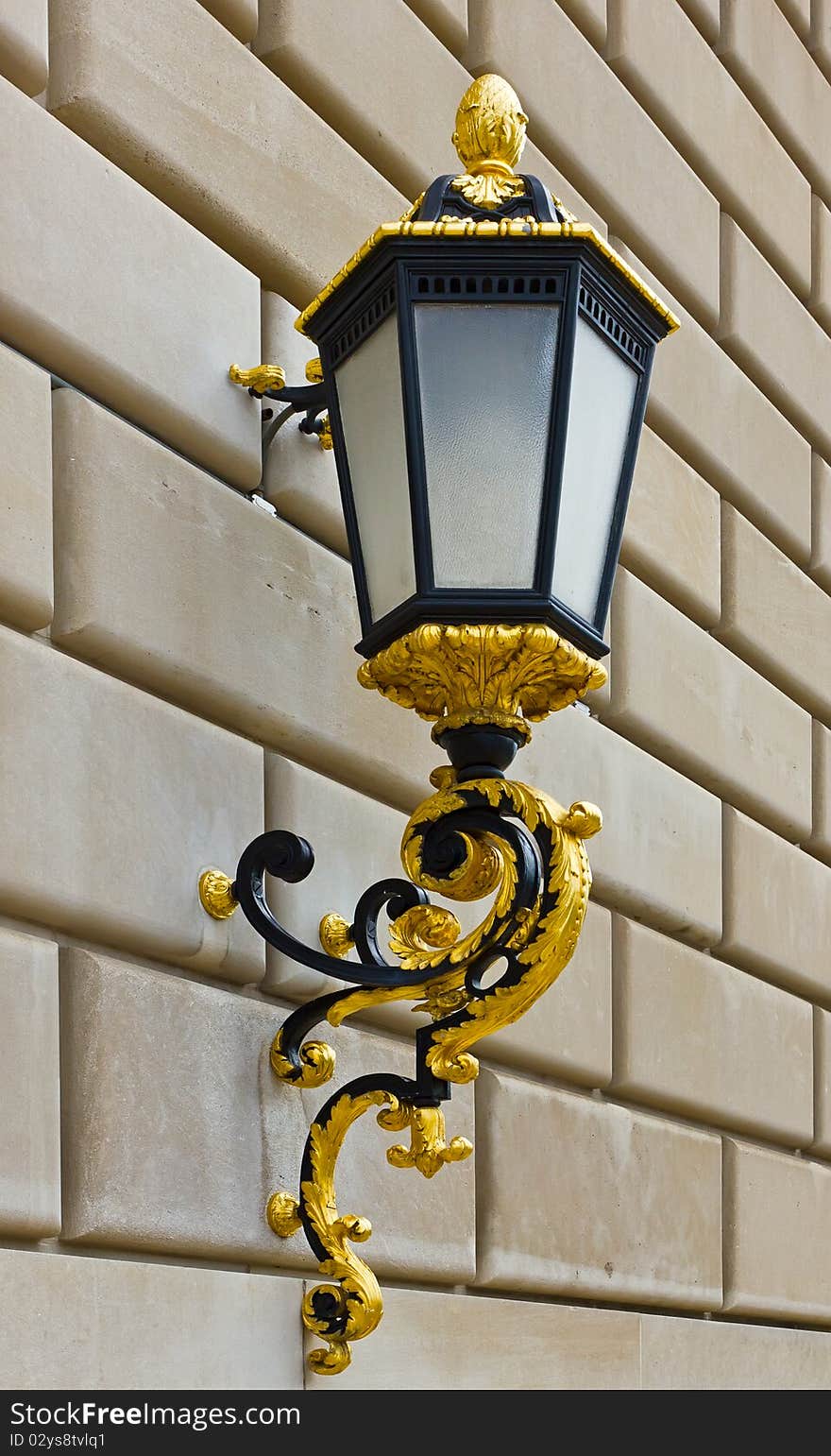 Classic street lantern with gold details on brick wall. Classic street lantern with gold details on brick wall