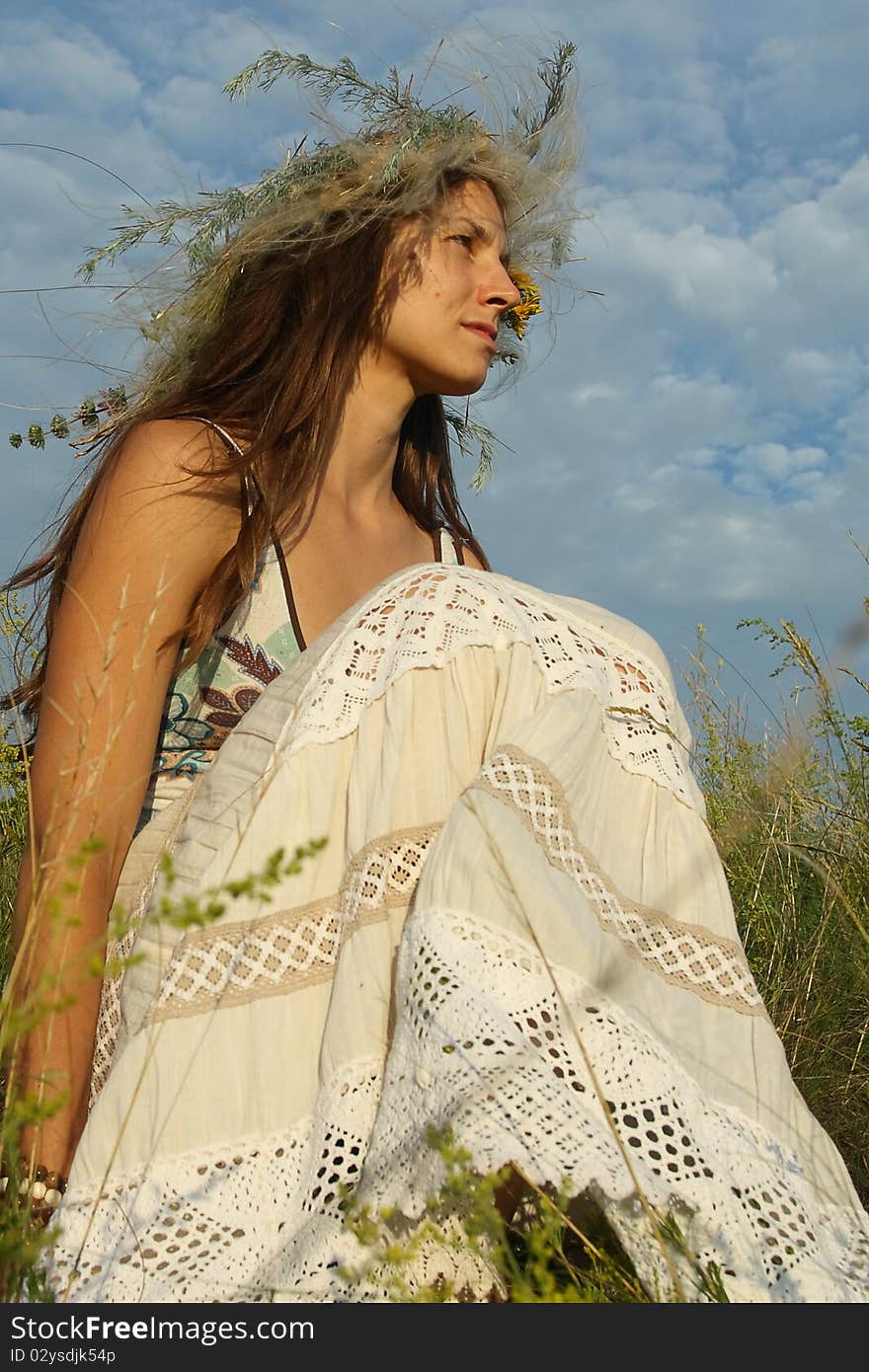 The woman sits in a grass