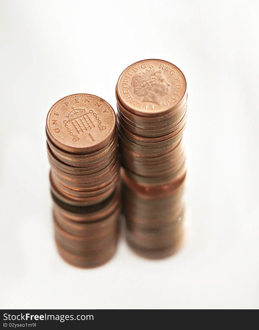 Two piles of British pennies isolated on white. Two piles of British pennies isolated on white.