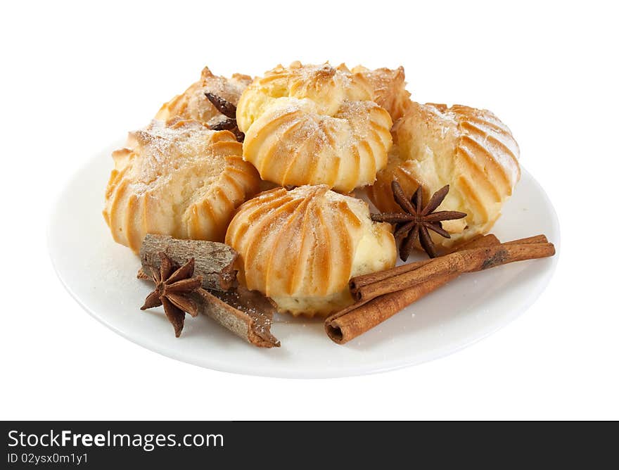 Eclairs and cinnamon on a plate, isolated on a white background