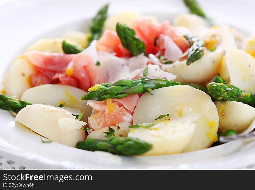 Prosciutto with asparagus and potatoes on white plate