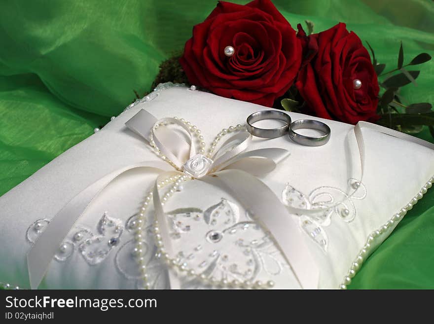 White ring pillow with red roses