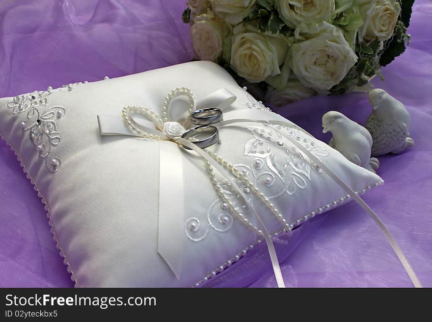 White ring pillow with white roses