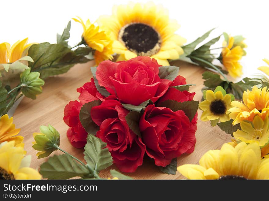 Bunch of roses with sunflowers on wood board