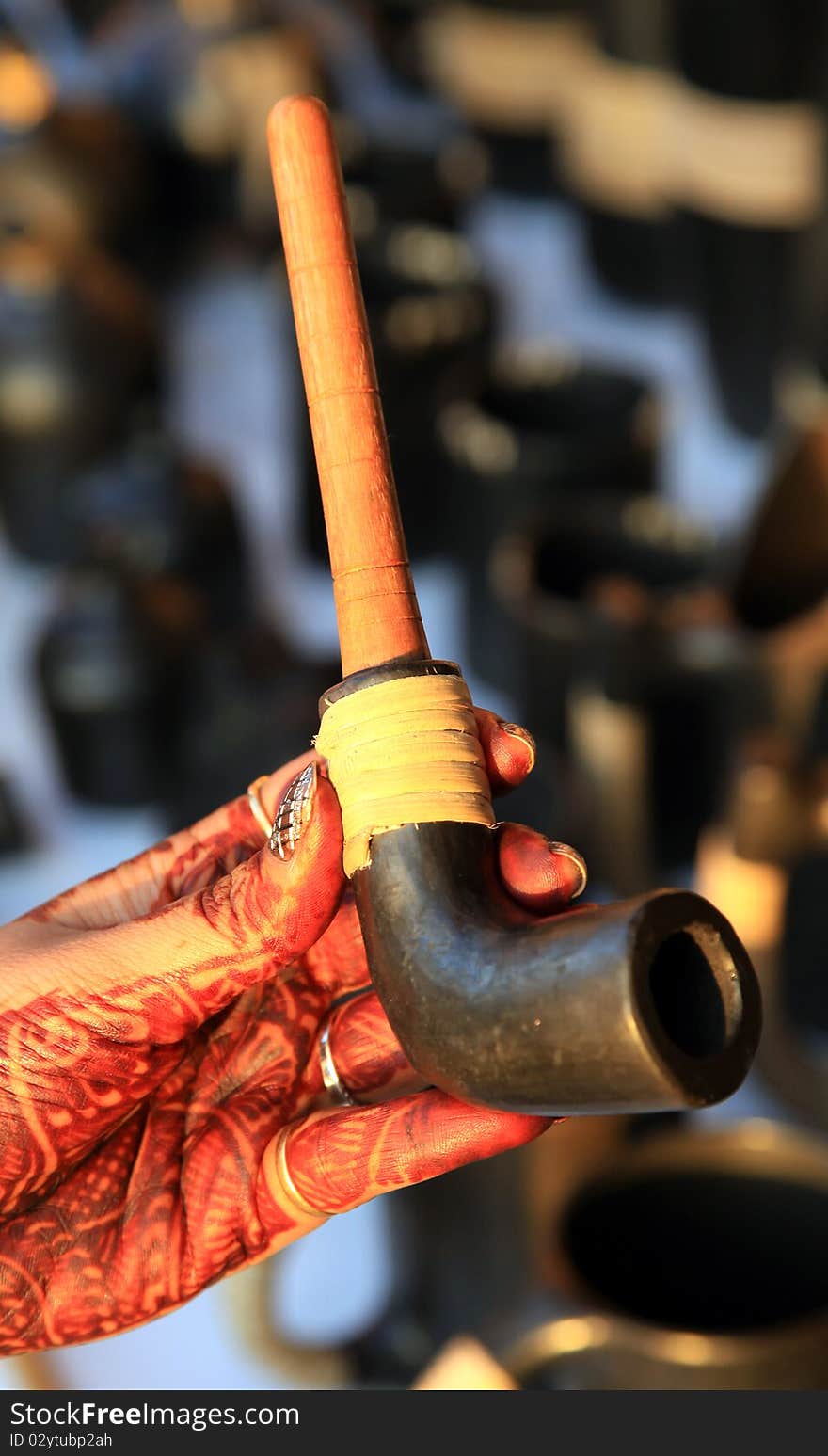 Female hand holding antique cigar pipe.