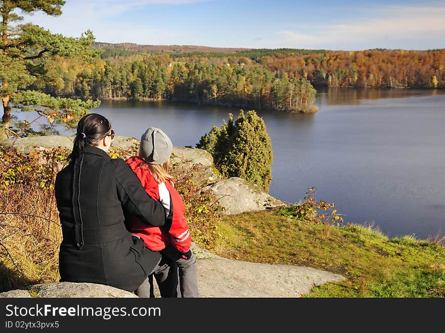 Mother and daughter admire a beautiful autumn's landscape. Mother and daughter admire a beautiful autumn's landscape