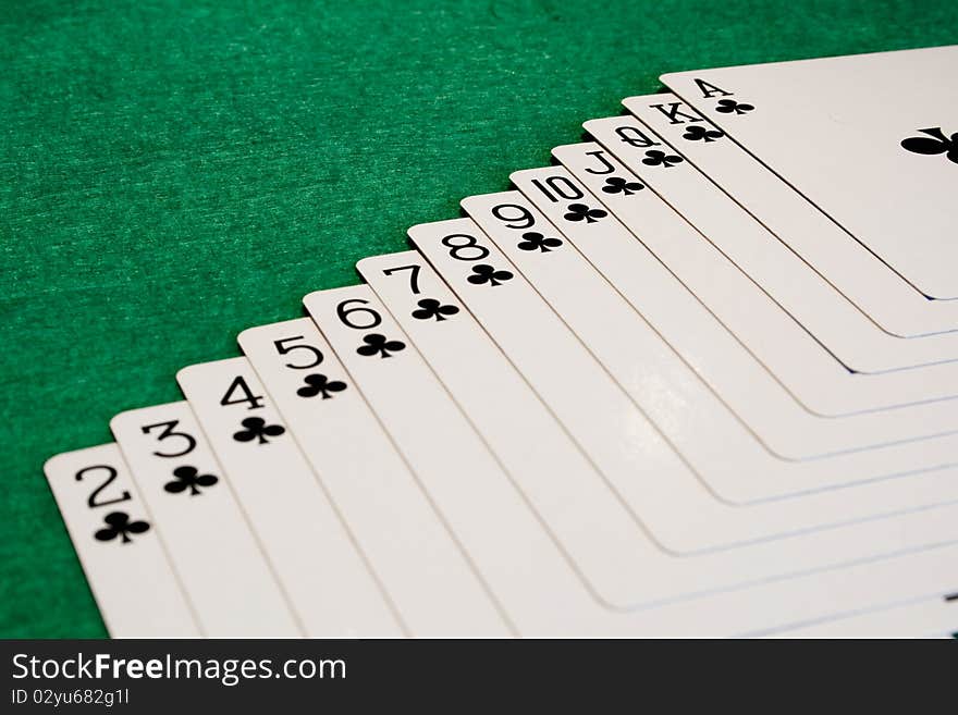 The suit of clubs photographed on a poker mat