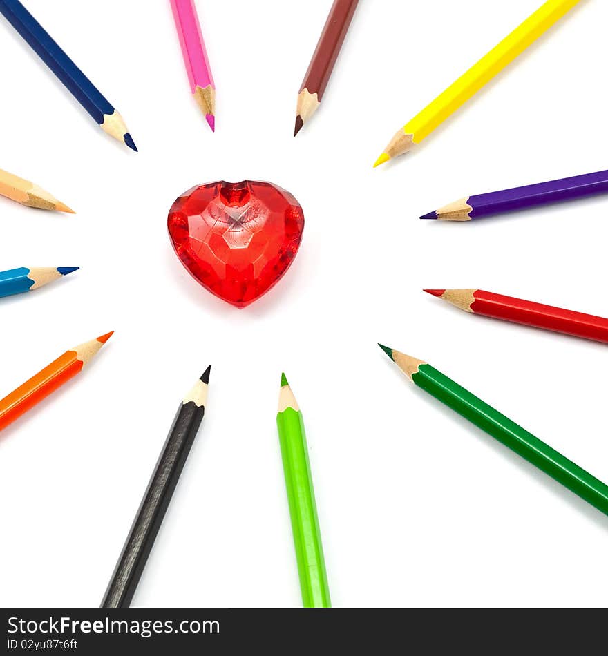 Red crystal heart surrounded with color pencil. Red crystal heart surrounded with color pencil