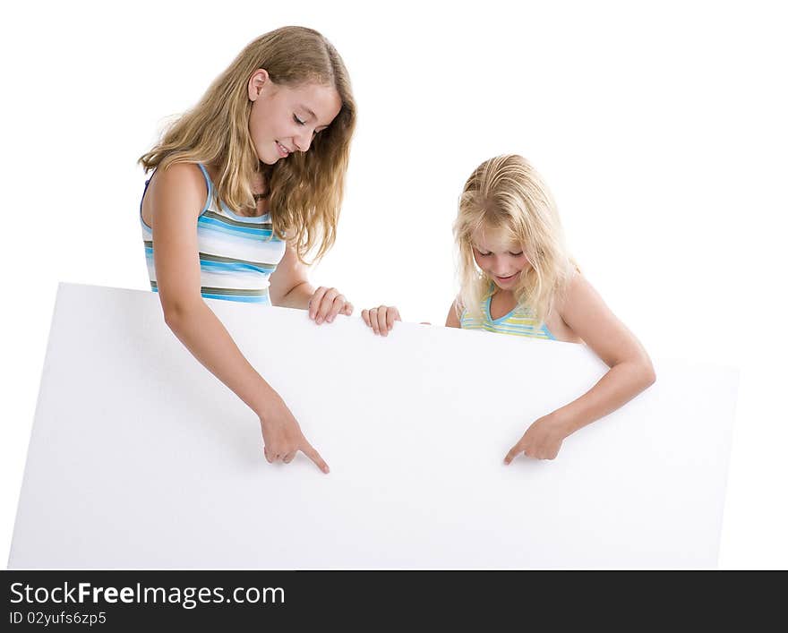 Two blond girls holding a blank display board, isolated on white background. Two blond girls holding a blank display board, isolated on white background