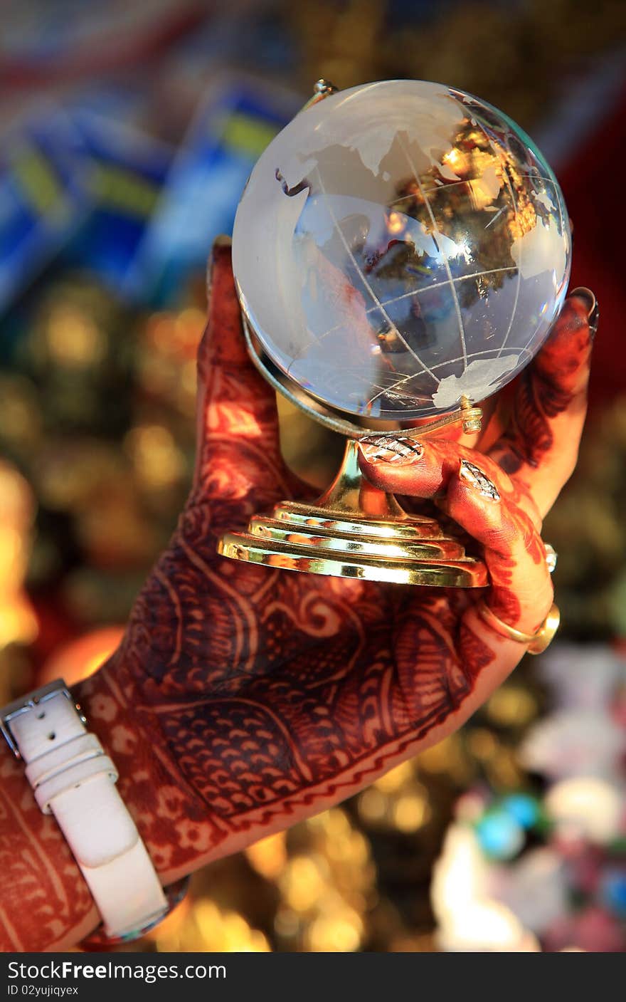 Female hand holding glass globe in sunny day.