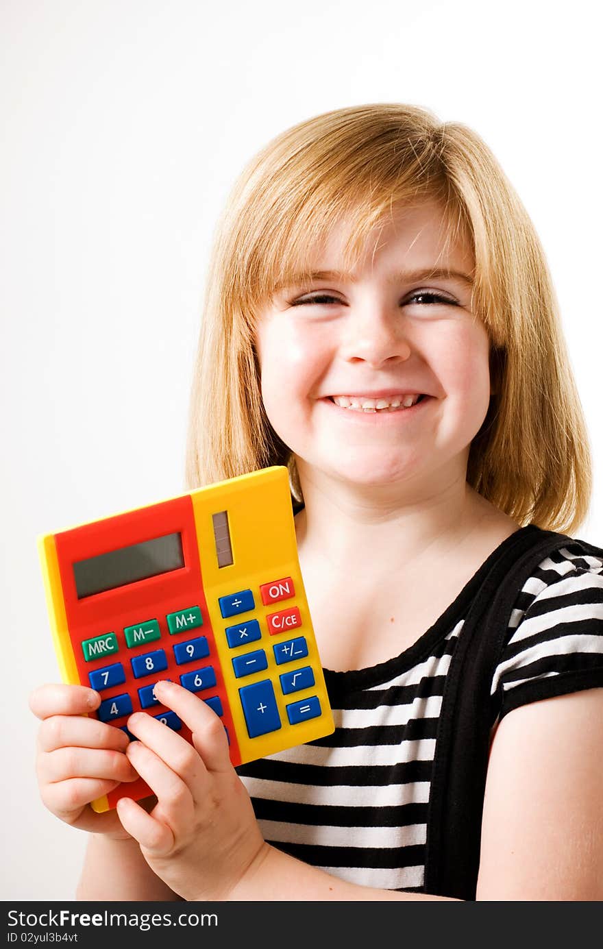 A vertical image of a young girl playing with a calculator. A vertical image of a young girl playing with a calculator