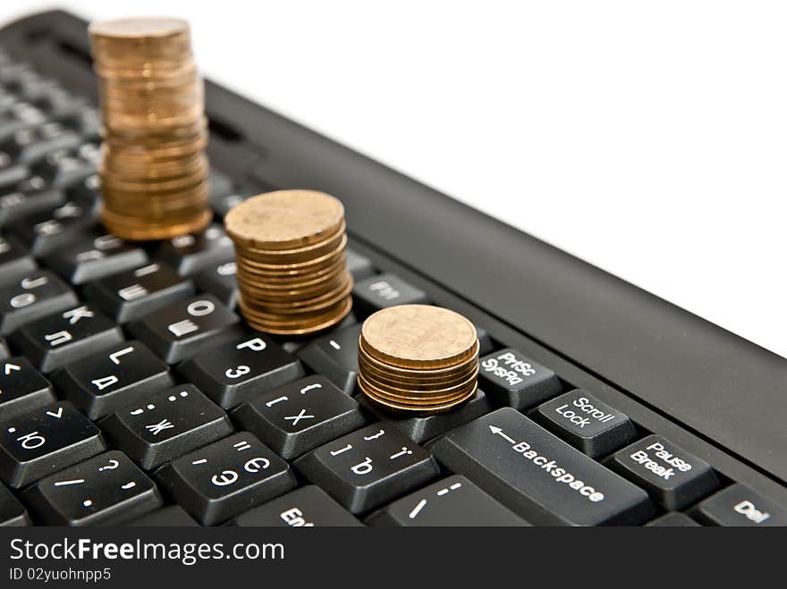 Line of coins on black computer keyboard. Isolated on white. Line of coins on black computer keyboard. Isolated on white