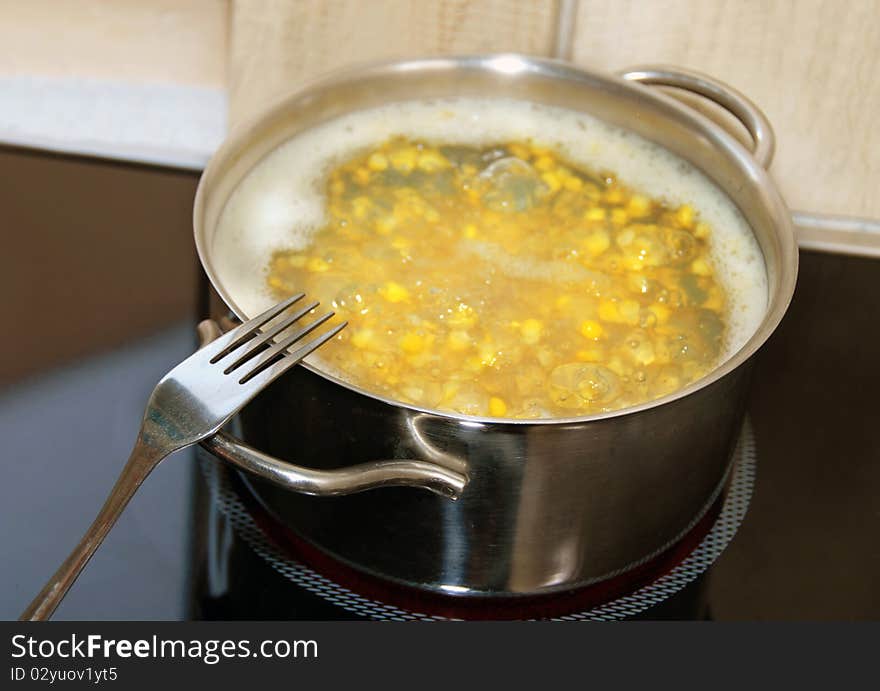 Boiling yellow corn in kitchen pot on stove. Boiling yellow corn in kitchen pot on stove