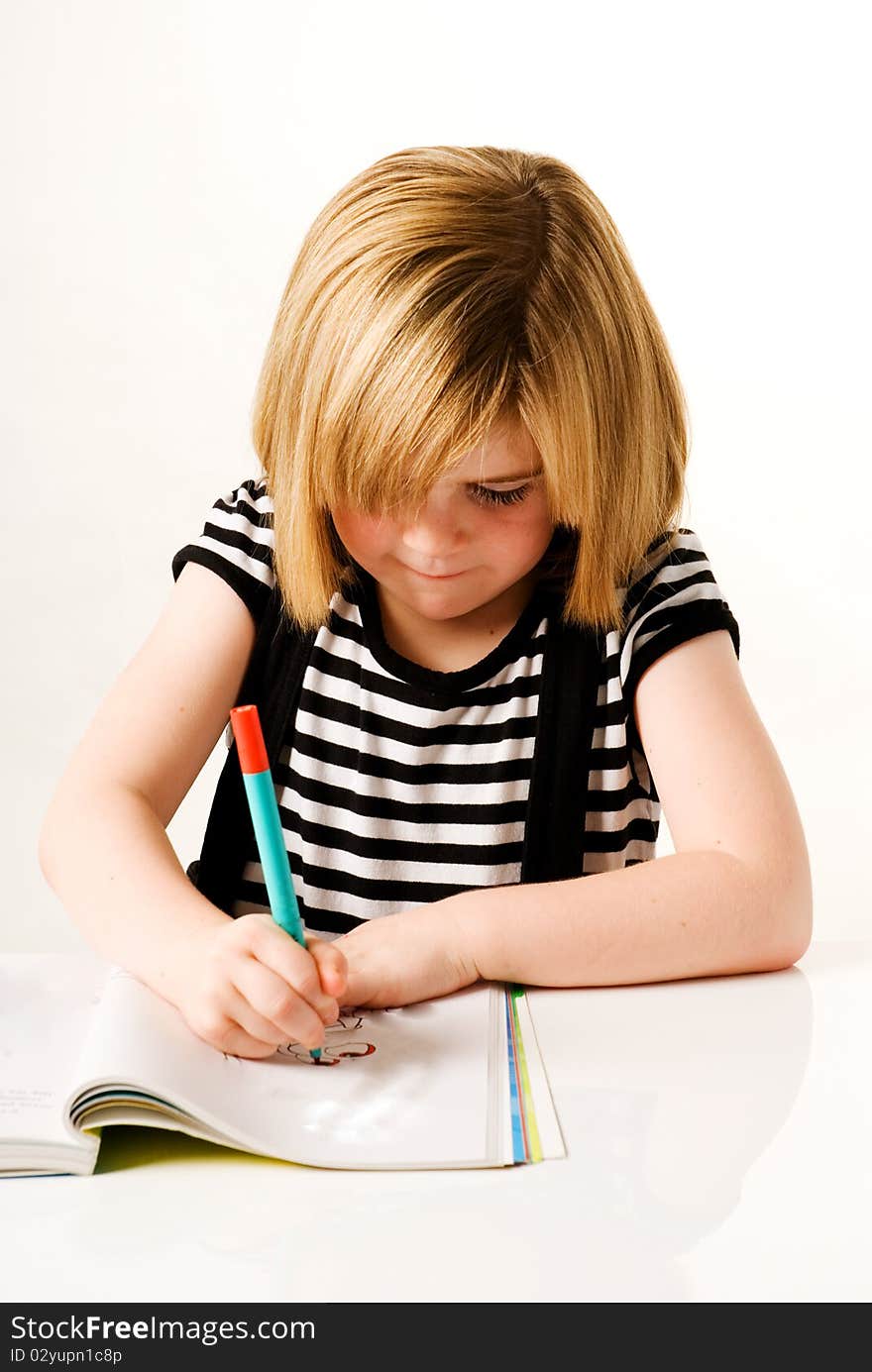 A vertical image of a young girl drawing in her colouring book. A vertical image of a young girl drawing in her colouring book