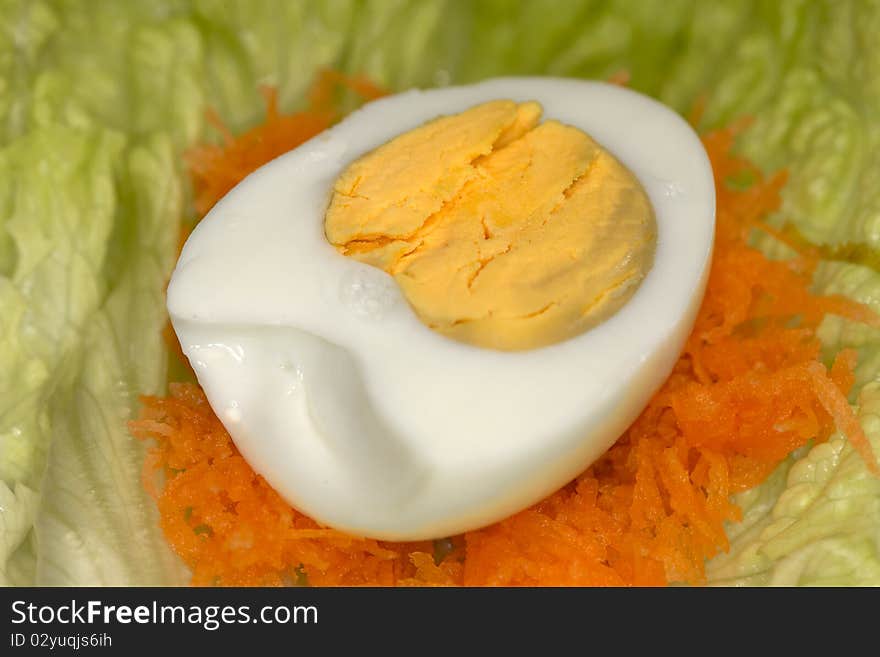 Half egg on chopped carrot and green salad. Half egg on chopped carrot and green salad