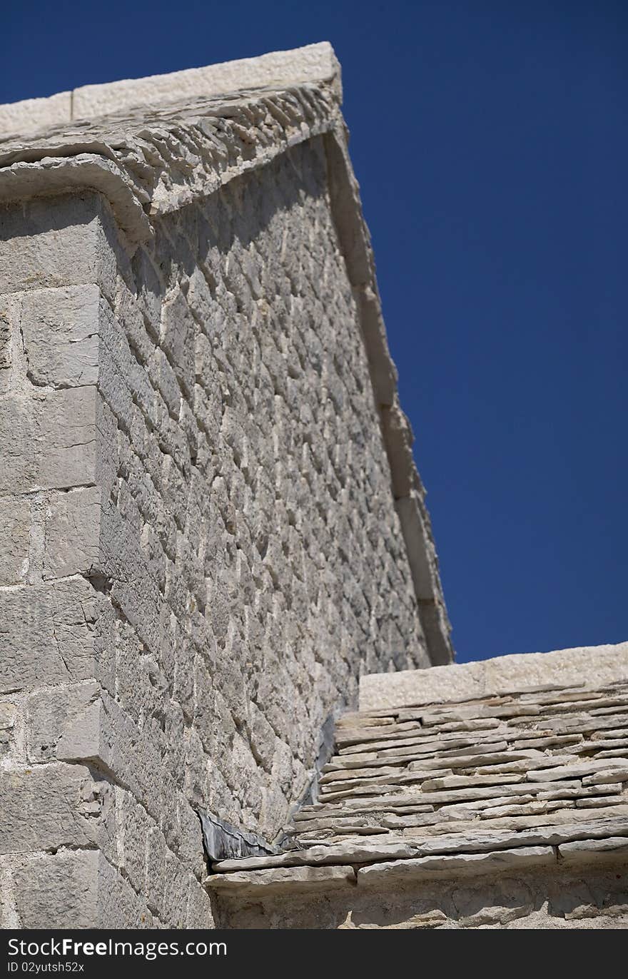 Stone house with stone roof, blue sky no clouds