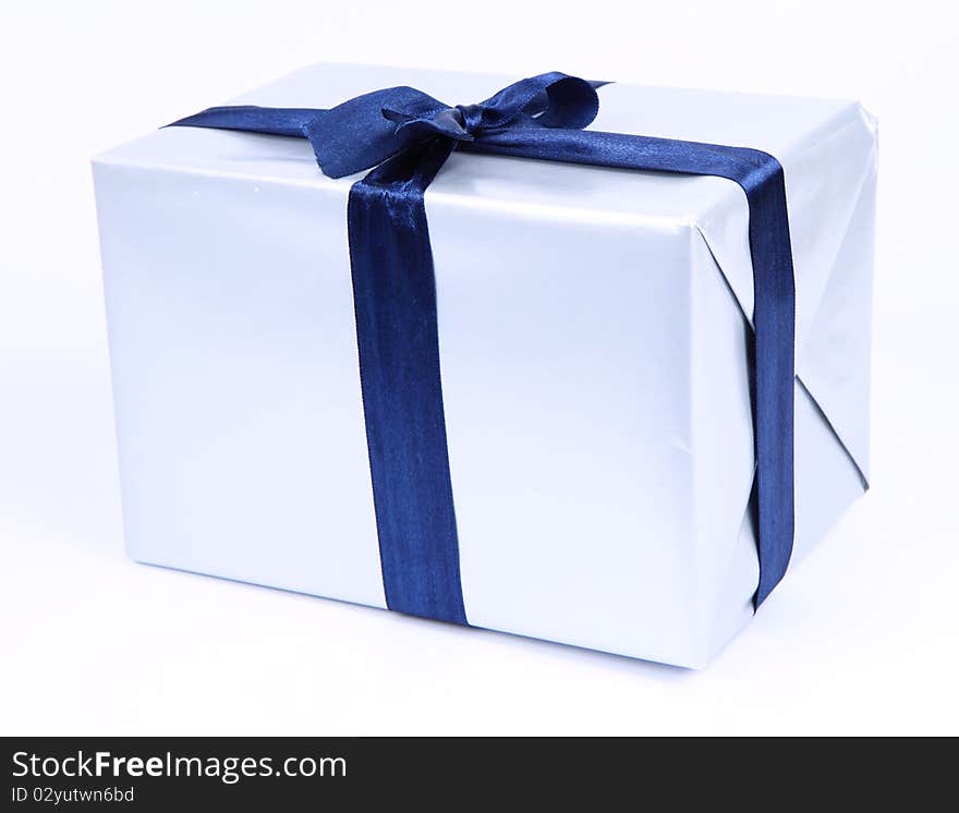 Gift in silver wrapping with a blue bow on white background