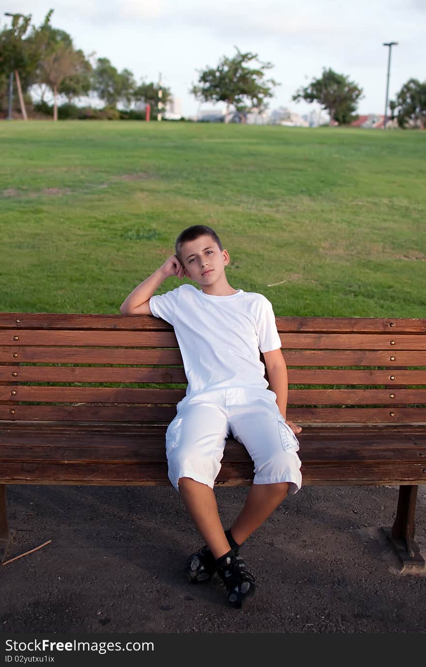 Schoolboy  sitting on bench  .