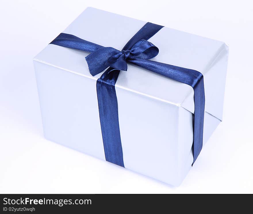 Gift in silver wrapping with a blue bow on white background