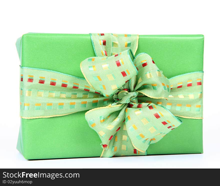 Gift in green wrapping with a green bow on white background