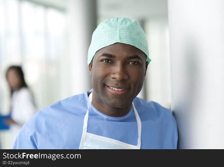 Portrait of a male surgeon, colleagues on background