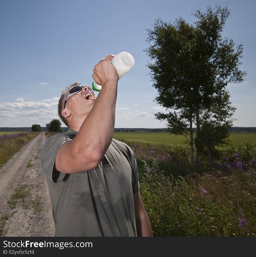 Male athlete drinking water on hot summer day. Male athlete drinking water on hot summer day.