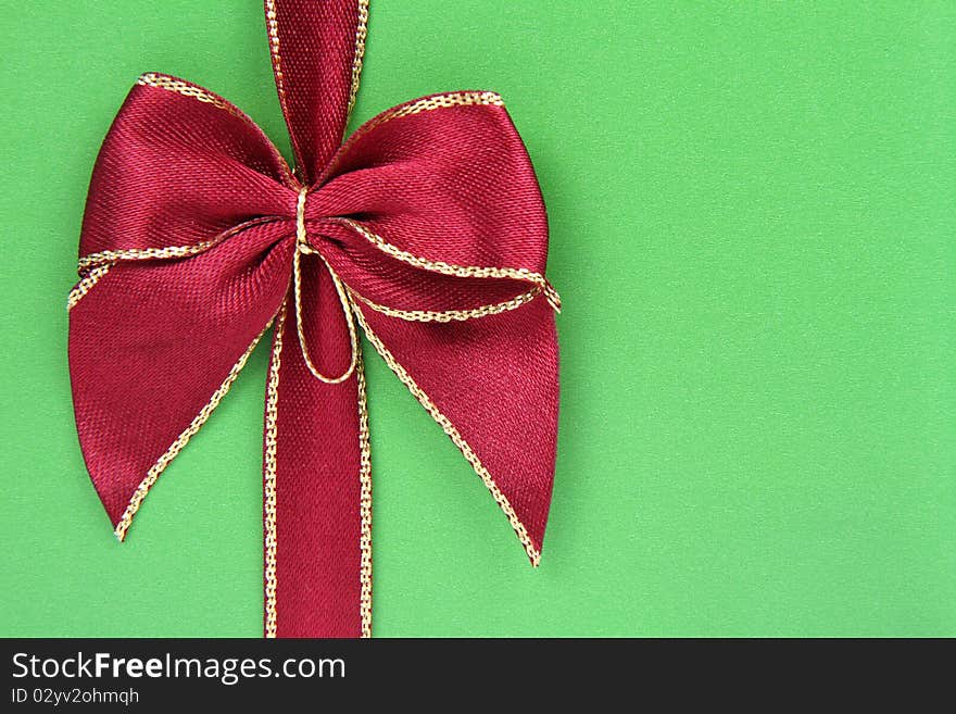 Gift in green wrapping with a red bow in close up. Gift in green wrapping with a red bow in close up