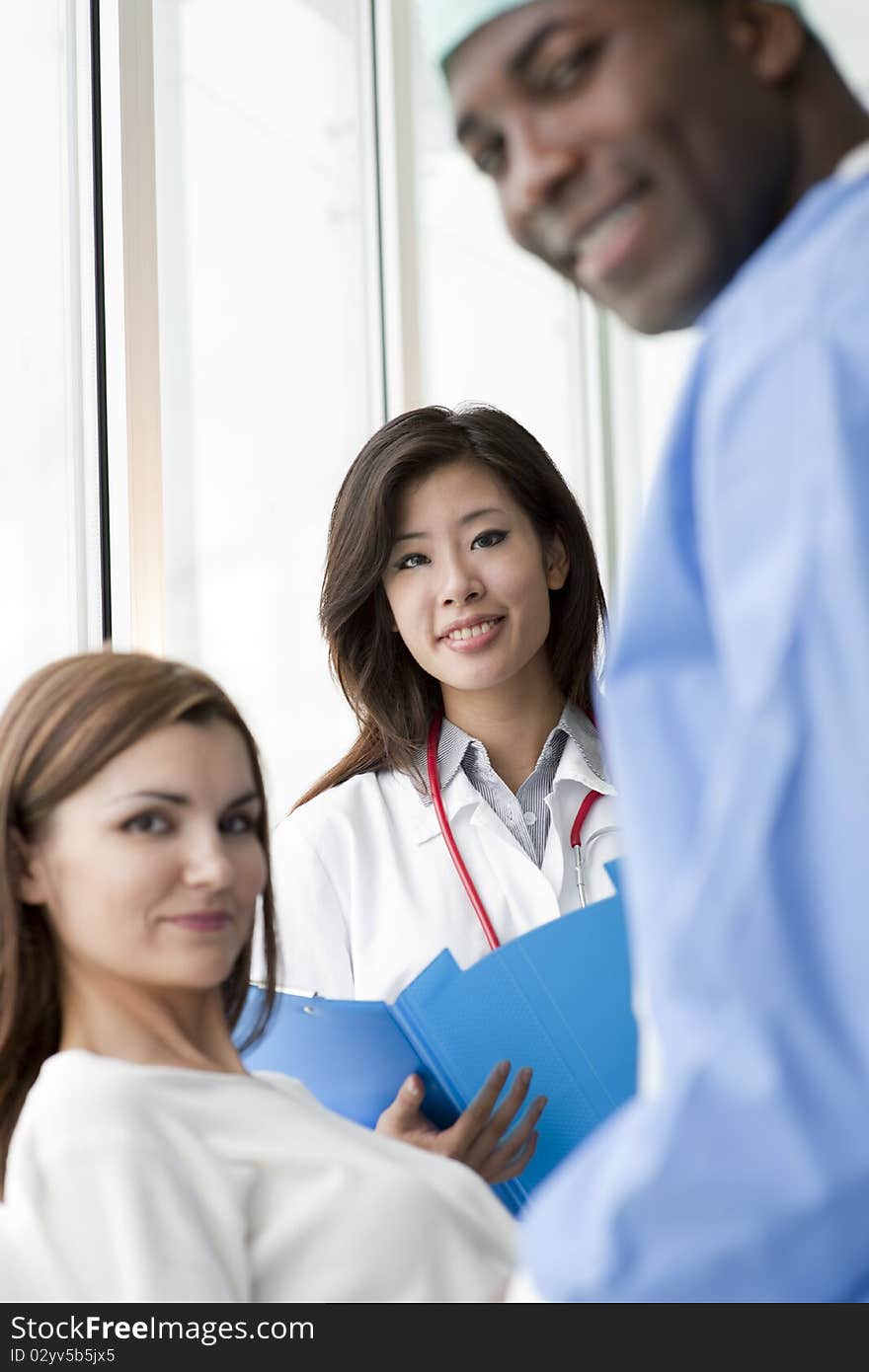 Doctor and surgeon speaking with a female patient. Doctor and surgeon speaking with a female patient