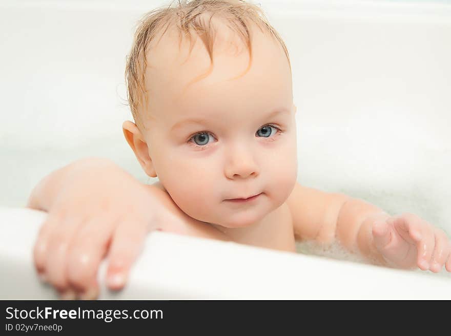 Cute adorable baby sit in water in foam bath